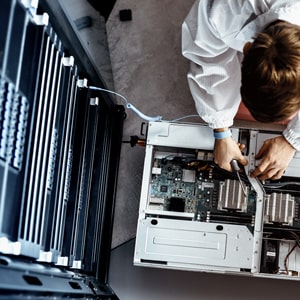 An IT engineer servicing parts of a computer.