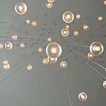 Many light bulbs attached by a long string, giving a drop like an effect. 