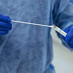 Notarzt in PSA mit Rachenabstrich fuer SARS-CoV-2 PCR-Testung in der Hand, Grevenbroich, NRW, Deutschland