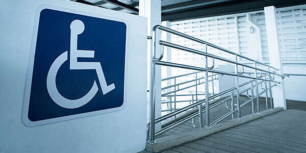 Concret ramp way with stainless steel handrail with disabled sign for support wheelchair disabled people.
